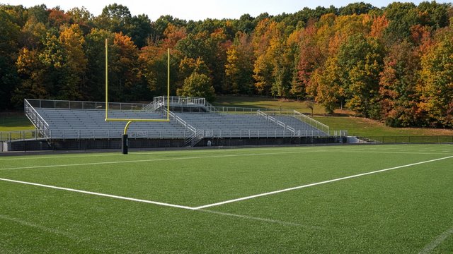Empty college football stadium end zone on an autumn afternoon