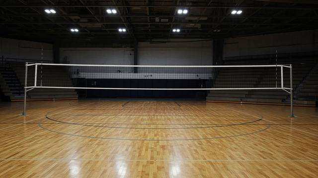 High school volleyball net and gym floor before tip