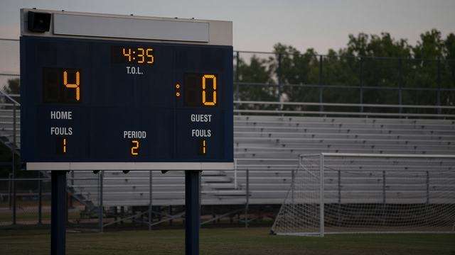 High school soccer scoreboard after a weekday home match